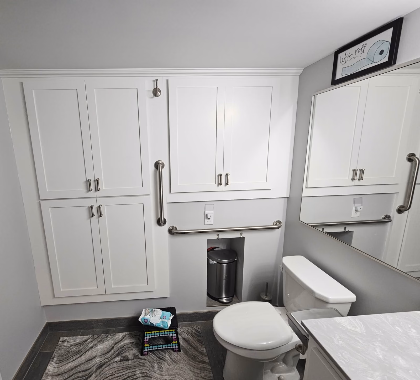 Bathroom remodel with custom white cabinetry and grab bars